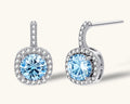 Sterling silver drop earrings featuring cushion-cut blue moissanite stones surrounded by sparkling halo settings