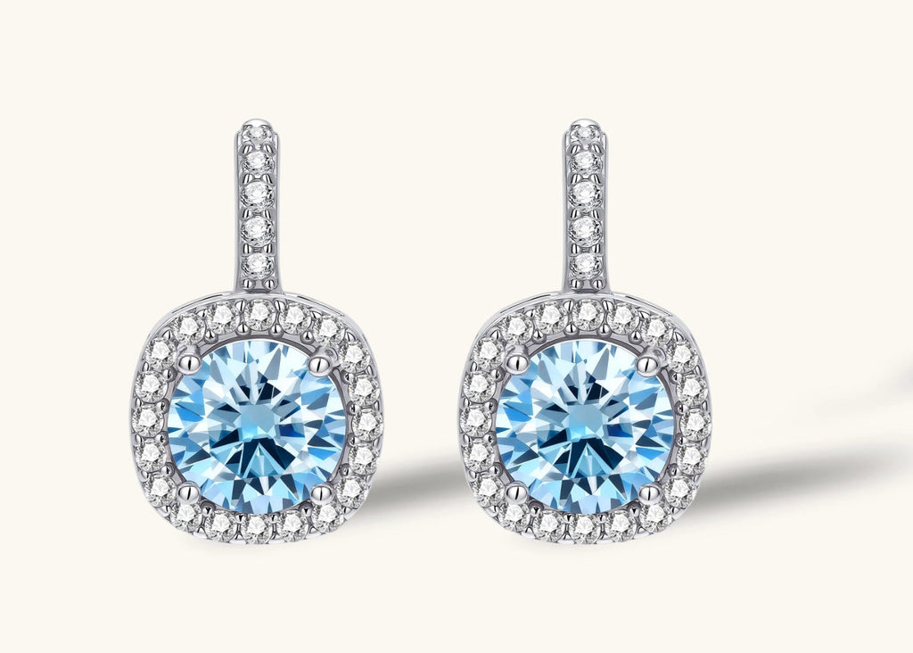 Sterling silver drop earrings featuring cushion-cut blue moissanite stones surrounded by sparkling halo settings